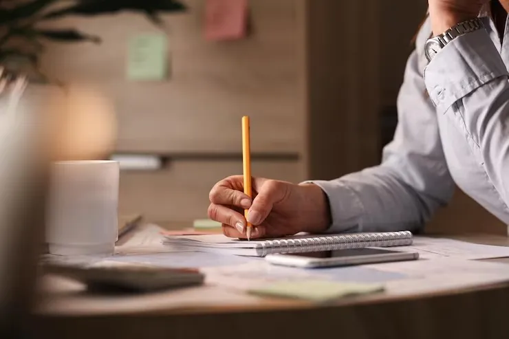Project outsourcing planning with pencil and documents